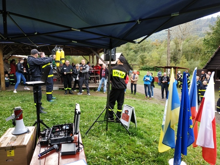 na zdjęciu dwóch zawodników podnosi butle tlenowe (kliknięcie spowoduje powiększenie obrazu)